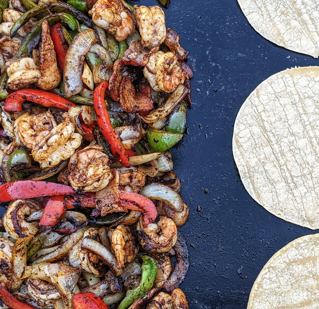 Shrimp, bacon and peppers with corn tortillas on a skillet, to make shrimp tacos.