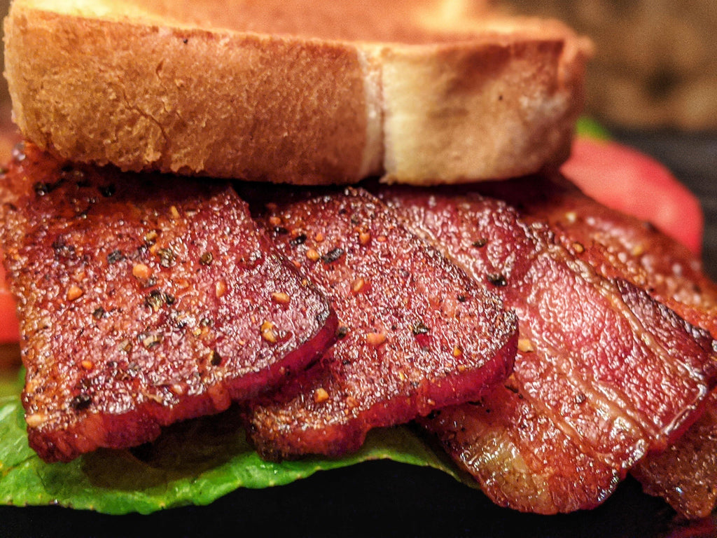 Dr. Bacon Ultimate BLT Sandwich with four slices of thick-cut bacon, tomato, and fresh romaine lettuce on toasted brioche bread.