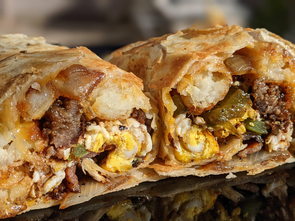 Dr. Bacon O.G. Spice Rub Ultimate Breakfast Burrito with seasoned bacon, sausage, eggs, melty cheese, tater tots, onions and pepper, cooked on a griddle or cast iron skillet